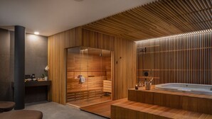 Un spa moderne avec des lambris en bois, un grand jacuzzi et un espace de détente équipé de tables de massage.