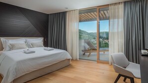 Une chambre moderne dotée d’un grand lit, d’un balcon avec vue et d’un coin salon.