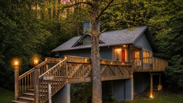 A cabin with a wooden staircase, a deck, and a small porch. - Dove's Nest: Beautiful, Pet Friendly Cabin Alongside a Creek near Downtown Gatlinburg (Gatlinburg)