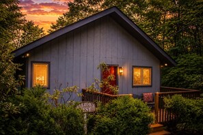 A wooden cabin with a porch, surrounded by greenery, and a sign reading 'Warrow's West'. - Sparrow's Nest: Cozy Cabin in the Smokies (Gatlinburg)