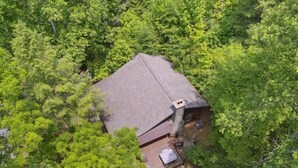 Vue aérienne d’une maison entourée d’un feuillage verdoyant et dense.