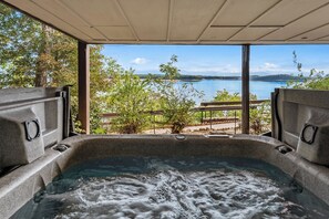 A hot tub with a view of a lake and trees.