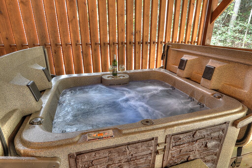 Un jacuzzi con un fondo de madera y una botella de champán.