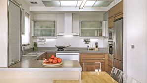 Een moderne keuken met roestvrijstalen apparatuur, een centraal kookeiland en een eethoek.