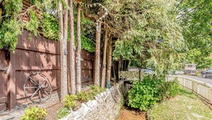 A narrow stone-lined pathway flanked by greenery and a wooden fence. - 2 bedroom accommodation in Abbotskerswell, nr Newton Abbot (Abbotskerswell, nr Newton Abbot)