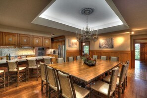 A spacious kitchen with wooden cabinets, a large island, and a chandelier. - Mountain High View: This Mountain Home is the Perfect Getaway (Sevierville)