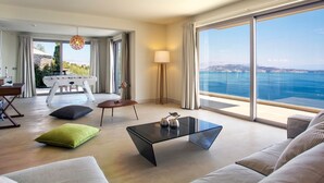 Una sala de estar moderna con una mesa de centro de vidrio, un sofá y vista al mar.