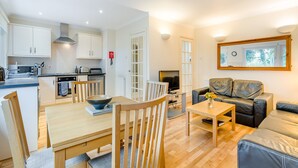 A compact living space with a kitchen, dining area, and seating area. - Burnside West Cottage- UK39596 (St Andrews)