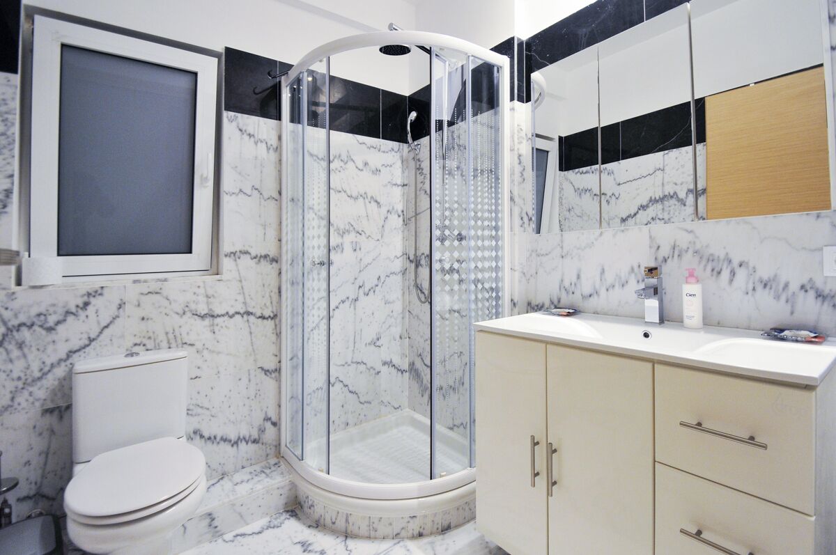 Ein Badezimmer mit Duschkabine, Toilette und Waschtisch mit Schubladen.