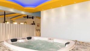 A modern spa room with a large hot tub, a ceiling with blue lighting, and a white wall with a wooden shelf. - Villa Chorio - Four Bedroom Villa, Sleeps 8 (Afandou)