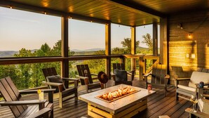 A wooden deck with outdoor seating, a fire pit, and a view of the mountains. - Swim Spa/Views/Gameroom/Theater/Luxe Design - Rabbit Run (Gatlinburg)