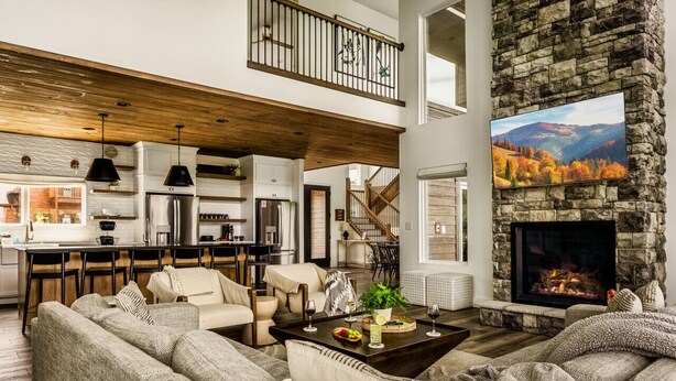 A spacious living area with a stone fireplace, a dining area, and a kitchen. - Swim Spa/Views/Gameroom/Theater/Luxe Design - Rabbit Run (Gatlinburg)