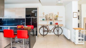 Une cuisine moderne avec des tabourets de bar rouges, un vélo et un radiateur blanc.