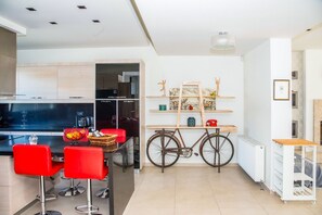 Une cuisine moderne avec des tabourets de bar rouges, un vélo et un radiateur blanc.