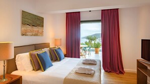 Une chambre d’hôtel avec un lit, une télévision, un tableau et une vue sur l’extérieur.