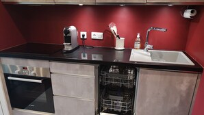 Una cocina compacta con horno Bosch, lavavajillas y fregadero.