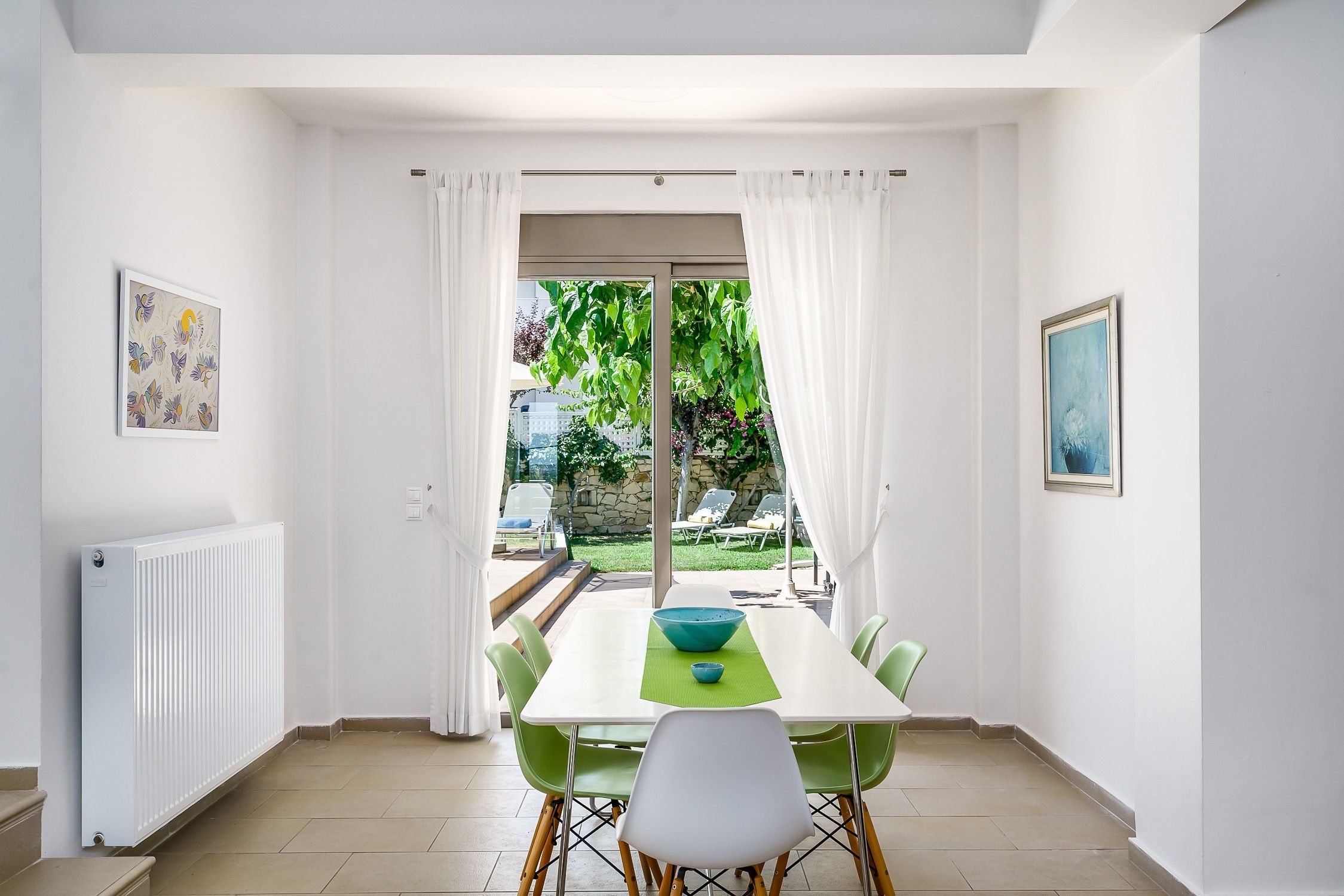 A dining area with a table, chairs, and a view of the outdoors.