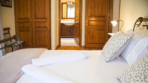 A bedroom with a bed, pillows, a bedside lamp, and wooden wardrobes. - Empress Sissi - Seven Bedroom Villa, Sleeps 14 (Gastouri)