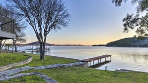 Una propiedad junto al lago con un camino de piedra, un muelle de madera y un pabellón junto al agua.