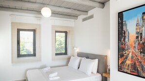 A bedroom with a large bed, two windows with blinds, a headboard, and a painting on the wall. - Villa Armenoi - Three Bedroom Villa, Sleeps 8 (Apokoronos)