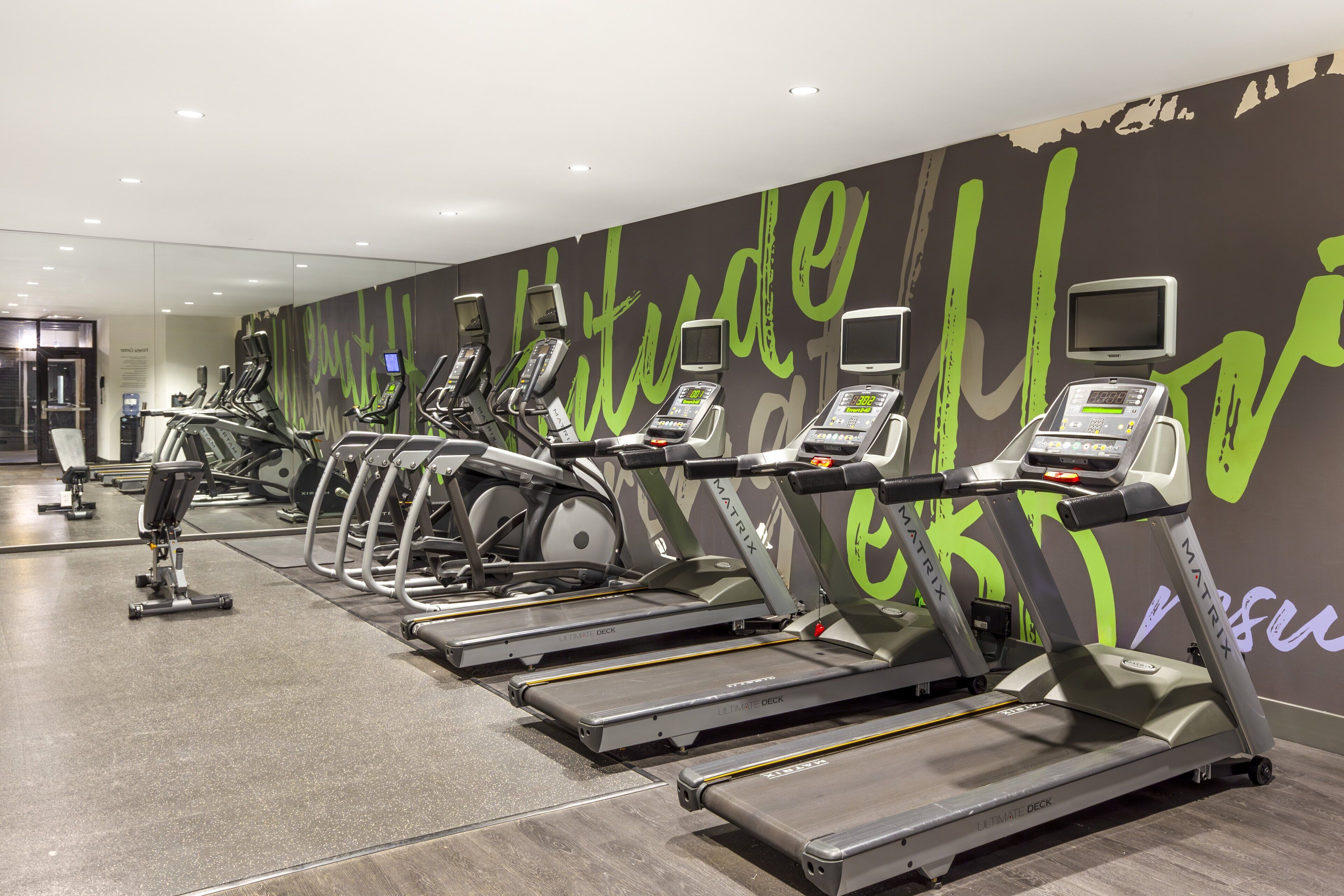 A gym with treadmills, ellipticals, and stationary bikes.