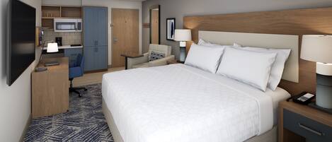 A hotel room with a large bed, a desk, a chair, a TV, a microwave, and a kitchenette.