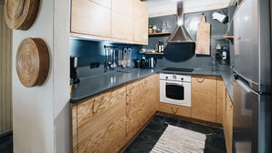 A modern kitchen with wooden cabinets, a built-in oven, and a stainless steel refrigerator. - Villa Artemida - Three Bedroom Villa, Sleeps 8 (Agios Georgios Nilias)