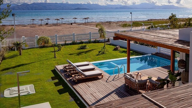 A poolside area with a view of the beach and mountains. - Villa Ammos - Two Bedroom Villa, Sleeps 6 (Kavos)