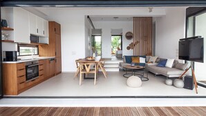 A modern interior with a kitchen, dining area, and living room. - Villa Ammos - Two Bedroom Villa, Sleeps 6 (Kavos)
