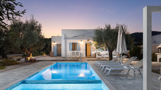 A swimming pool with lounge chairs, a patio area, and a building with a door and windows. - Kalathos Aspro - Two Bedroom Villa, Sleeps 4 (Kalathos)