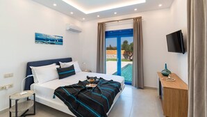 A modern hotel room with a bed, a small desk, a TV, and a balcony with a view.