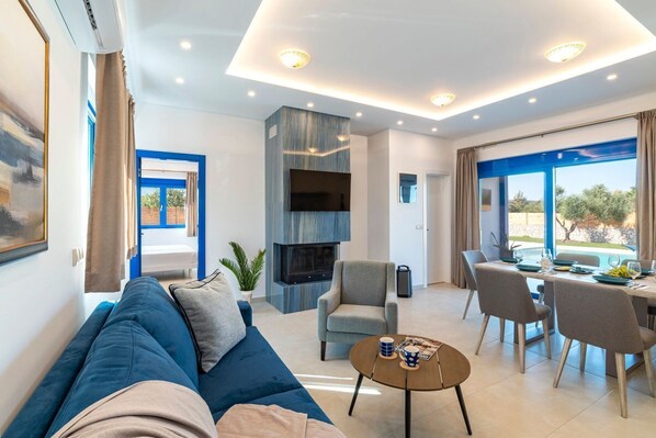 Een moderne woonkamer met een bank, salontafel en een eethoek.