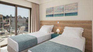 Ein Hotelzimmer mit zwei Betten, einem Balkon mit Stuhl und Meerblick.