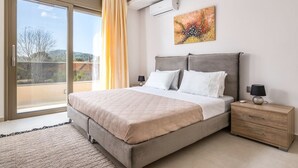 Une chambre à coucher avec un grand lit, une table de chevet, une lampe et un tableau au mur.