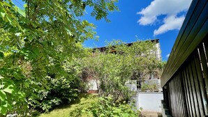 Un jardin avec un chemin dallé menant à un bâtiment.