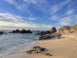 A beach with rocky formations and a clear sky.