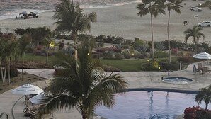 Een resort met zwembad, strand en uitzicht op de oceaan.