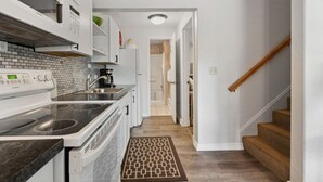 A kitchen with a stove, microwave, and sink. - Whitefish Lake Condo, 14BD, hillside! (White)