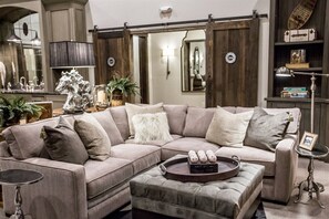 Un canapé modulable avec une table d’appoint, une petite table ronde et un plateau décoratif contenant des œufs.