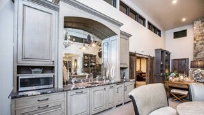 A spacious kitchen with a large island, built-in appliances, and a stone accent wall.