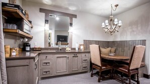 A kitchen with a wooden island, built-in cabinets, a large mirror, and a chandelier.