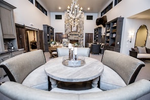 Relax in a stylish living area with a round table, plush chairs, and a stone fireplace.