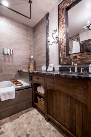 Ein Badezimmer mit einem Holzkosmetikschrank, einem großen Spiegel und einer Duschkabine.