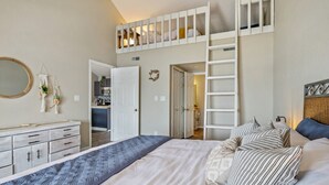 Un dormitorio con una cama individual superpuesta, un armario, una mesita de noche y un espejo.