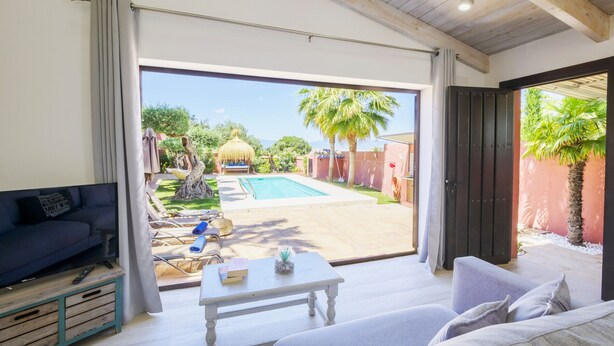A modern living room with a pool, a sofa, a coffee table, and a view of the pool area. - Cubo's Finca Las Palmeras / Private pool / Free Wifi (Alhaurin de la Torre)