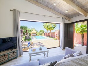 A modern living room with a pool, a sofa, a coffee table, and a view of the pool area. - Cubo's Finca Las Palmeras / Private pool / Free Wifi (Alhaurin de la Torre)