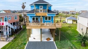 A two-story house with a balcony, a front porch, and a small deck. - Brand NEW Beach House Coastal Point  (Bolivar Peninsula)