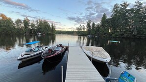 A dock with boats and a chair.