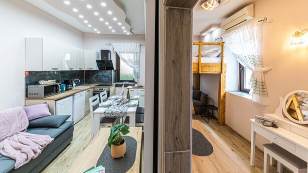 A compact, modern apartment with a kitchenette, dining area, and a cozy living space.