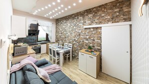 A compact living space with a kitchenette, a dining area, and a sofa.